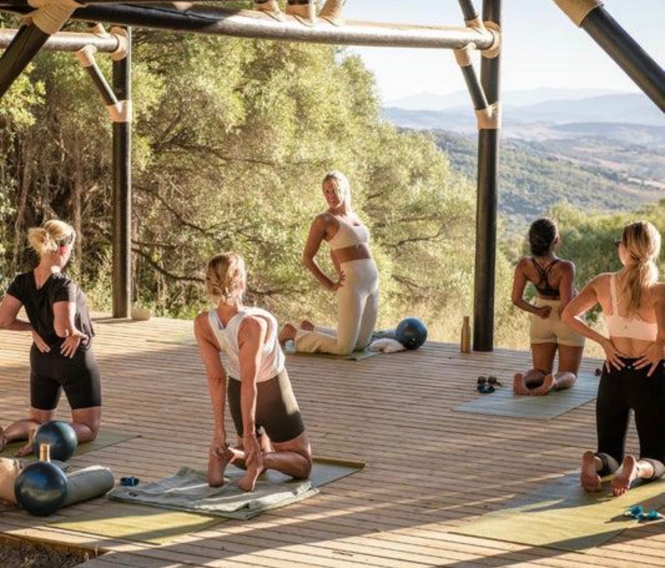 Women practicing Pilates outdoors in an elevated natural ranch setting